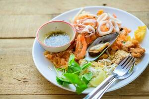 Stir-fried rice noodles or Pad Thai with shrimp, mussels and squid photo