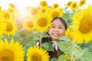 contento linda asiático niña sonrisa con girasol, foto