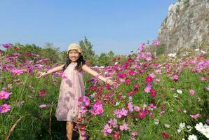 Happy cute asian girl smile in cosmos garden photo