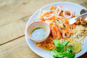 Mussels and stir-fried rice noodles or Pad Thai on fork. photo