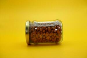 closed glass bottles filled with peanuts that have been peeled. photo