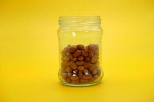 open glass jar half filled with shelled nuts photo