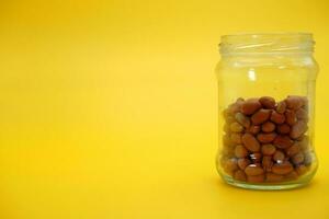 open glass jar half filled with shelled nuts photo