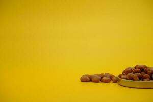 collection of peeled peanuts isolated on yellow background photo