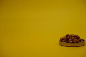 collection of peeled peanuts isolated on yellow background photo