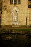 católico estatua con reflexión en un lago foto