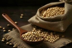 Soybeans on a wooden background in a wooden spoon and sackcloth photo