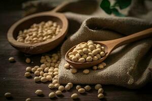 Soybeans on a wooden background in a wooden spoon and sackcloth photo