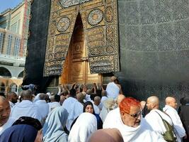 Mecca, Saudi Arabia, April 2023 - Umrah pilgrims from all over the world gather in the courtyard of Masjid al-Haram near the door of the Kaaba. photo