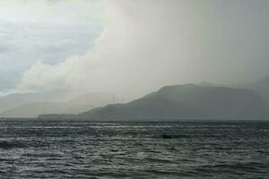 storm over the sea with mountains in the background photo