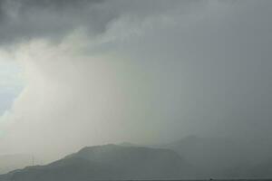 storm over the sea with mountains in the background photo