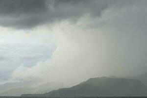 storm over the sea with mountains in the background photo