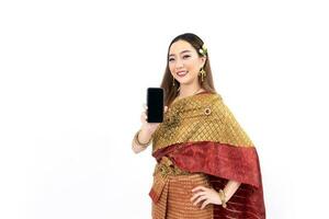Thai woman in elegant wealthy  traditional dress holding mobile phone for promoting culture in Thailand isolated on the white background photo