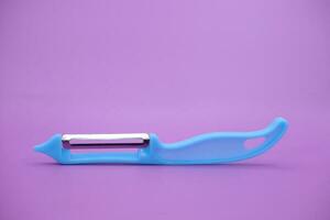 blue paring knife isolated purple background. kpas knife taken with a landscape angle. photo