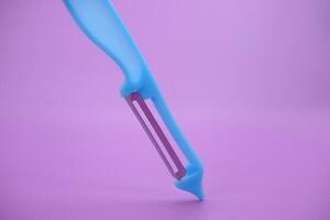 blue paring knife isolated purple background. kpas knife taken with a landscape angle. photo