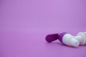 closed faucet isolated purple background. the faucet is white with a purple lid photo