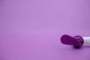 closed faucet isolated purple background. the faucet is white with a purple lid photo