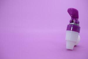 closed faucet isolated purple background. the faucet is white with a purple lid photo