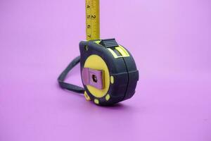 tape measure isolated purple background. measuring tool used by builders. photo