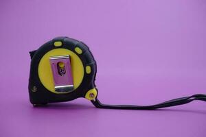 tape measure isolated purple background. measuring tool used by builders. photo