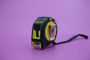 tape measure isolated purple background. measuring tool used by builders. photo