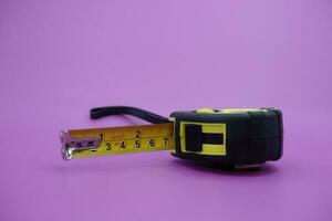 tape measure isolated purple background. measuring tool used by builders. photo