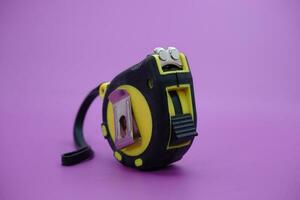 tape measure isolated purple background. measuring tool used by builders. photo