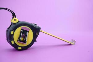 tape measure isolated purple background. measuring tool used by builders. photo
