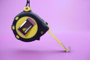 tape measure isolated purple background. measuring tool used by builders. photo