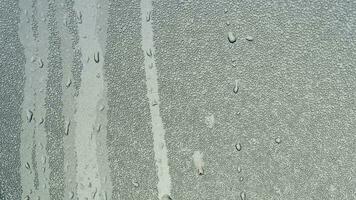 Abstract background of running path of water droplets on gray steel surface. Many fine spots of water droplets on the steel surface. photo