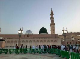 Medina, Saudi Arabia, May 2023 - Beautiful morning view of Masjid Al Nabawi, Medina. Visitors, courtyards outside the mosque, beautiful lights,  and electronic umbrellas can also be seen. photo