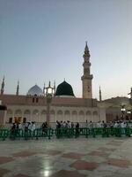 Medina, Saudi Arabia, May 2023 - Beautiful morning view of Masjid Al Nabawi, Medina. Visitors, courtyards outside the mosque, beautiful lights,  and electronic umbrellas can also be seen. photo