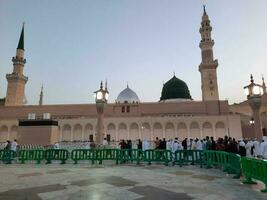 Medina, Saudi Arabia, May 2023 - Beautiful morning view of Masjid Al Nabawi, Medina. Visitors, courtyards outside the mosque, beautiful lights,  and electronic umbrellas can also be seen. photo