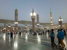 Medina, Saudi Arabia, May 2023 - Beautiful morning view of Masjid Al Nabawi, Medina. Visitors, courtyards outside the mosque, beautiful lights,  and electronic umbrellas can also be seen. photo