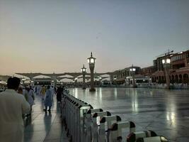 Medina, Saudi Arabia, May 2023 - Beautiful morning view of Masjid Al Nabawi, Medina. Visitors, courtyards outside the mosque, beautiful lights,  and electronic umbrellas can also be seen. photo