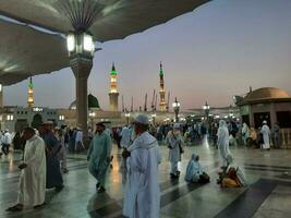 Medina, Saudi Arabia, May 2023 - Beautiful morning view of Masjid Al Nabawi, Medina. Visitors, courtyards outside the mosque, beautiful lights,  and electronic umbrellas can also be seen. photo