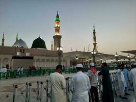 Medina, Saudi Arabia, May 2023 - Beautiful morning view of Masjid Al Nabawi, Medina. Visitors, courtyards outside the mosque, beautiful lights,  and electronic umbrellas can also be seen. photo