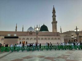 Medina, Saudi Arabia, May 2023 - Beautiful morning view of Masjid Al Nabawi, Medina. Visitors, courtyards outside the mosque, beautiful lights,  and electronic umbrellas can also be seen. photo