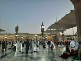 Medina, Saudi Arabia, May 2023 - Beautiful morning view of Masjid Al Nabawi, Medina. Visitors, courtyards outside the mosque, beautiful lights,  and electronic umbrellas can also be seen. photo