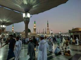 Medina, Saudi Arabia, May 2023 - Beautiful morning view of Masjid Al Nabawi, Medina. Visitors, courtyards outside the mosque, beautiful lights,  and electronic umbrellas can also be seen. photo