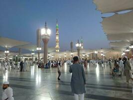 Medina, Saudi Arabia, May 2023 - Beautiful morning view of Masjid Al Nabawi, Medina. Visitors, courtyards outside the mosque, beautiful lights,  and electronic umbrellas can also be seen. photo