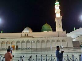 Medina, Saudi Arabia, May 2023 - Beautiful view of Masjid Al Nabawi, Medina, high minarets and mosque at night. The mosque presents a beautiful scene in the night lights. photo