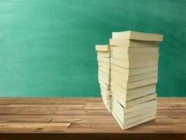 apilar de libros en de madera mesa allí es un verde tablero antecedentes. foto