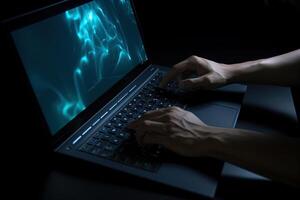 Man working on laptop computer in the dark. photo