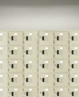 Deposit locker boxes or gym lockers inside of a room with one central opened door photo