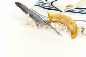 The Jewish Day of Atonement. Jewish holiday of Yom Kippur. Prayer shawl Tallit, Shofar horn and feather pen. photo