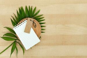 Notepad and blank rustic label on wooden work desk. photo