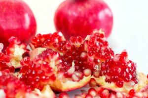 Close up of fresh fruit pomegranate seeds on white background. photo