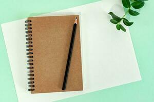 Office desk table with blank notebook, blank paper and pencil. photo