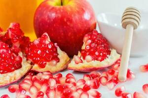 Apple, honey and pomegranate on white background. Jewish New Year - Rosh Hashana concept. photo